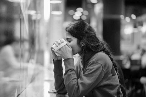 A woman is drinking a cup of kava tea
